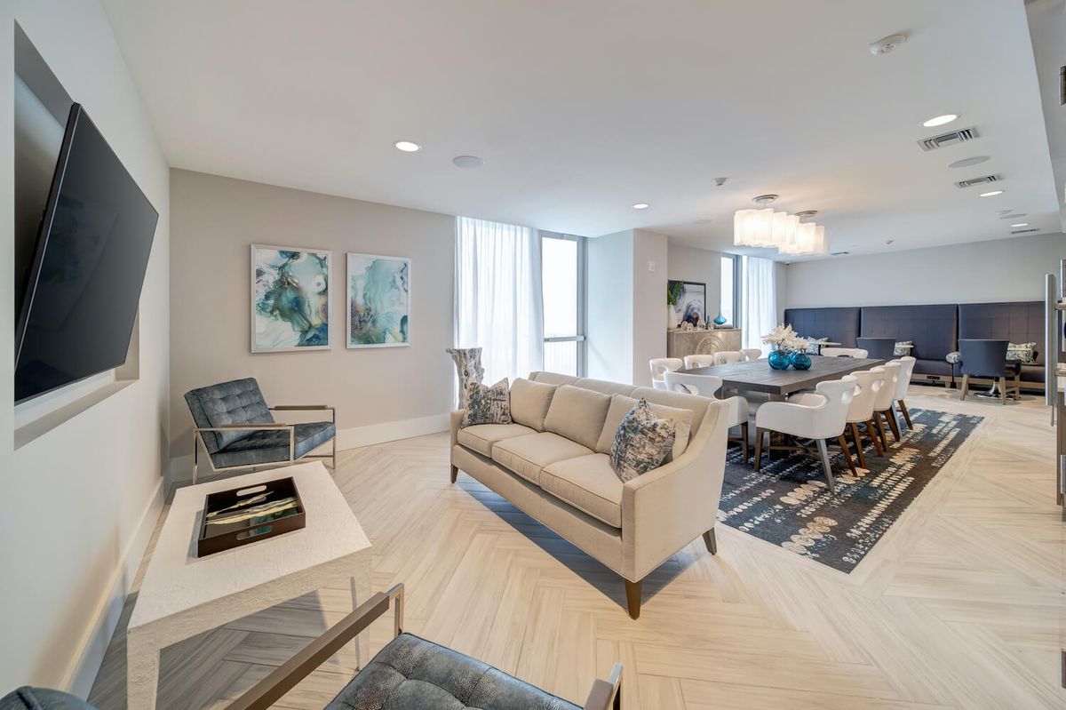 A modern living room with elegant furniture and a dining area, showcasing contemporary interior design.