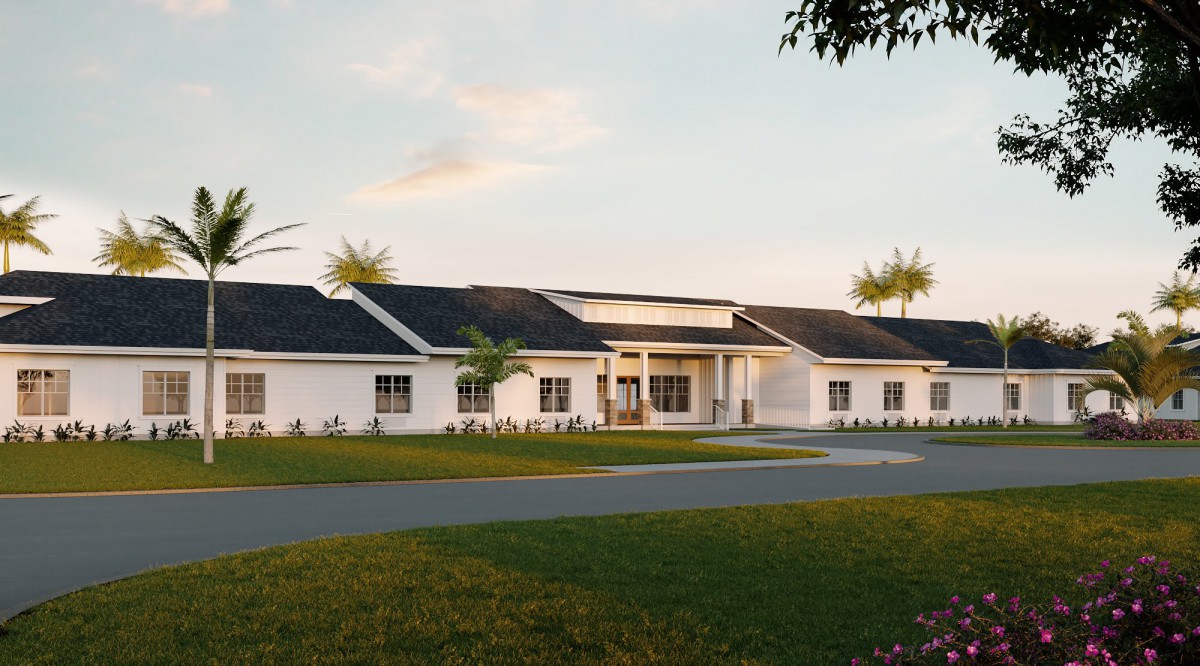 A large suburban house with a landscaped front yard at sunset.