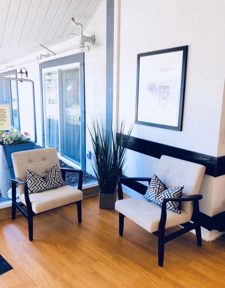 A modern waiting area with two chairs and decorative elements.