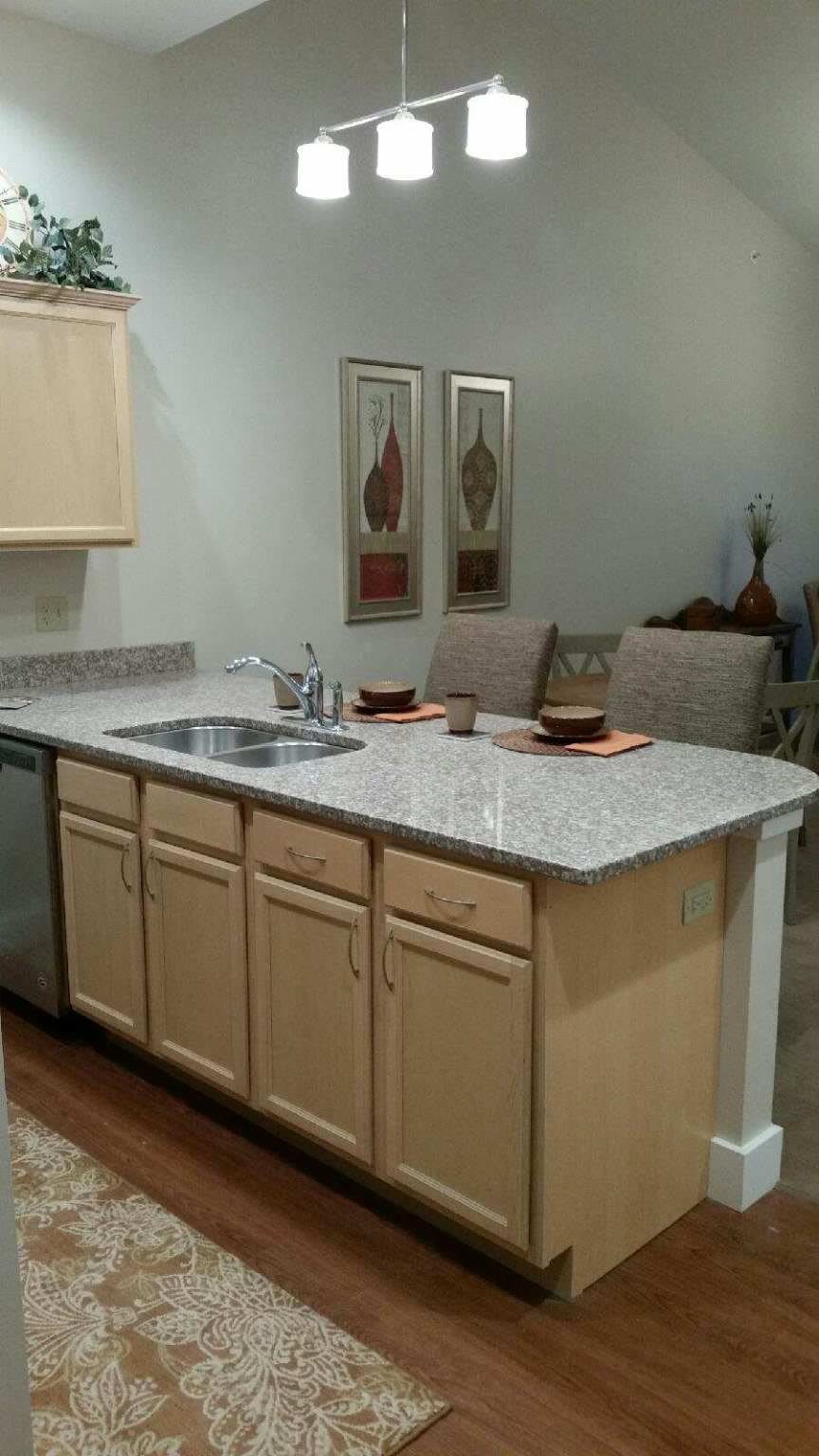 A modern kitchen with a granite countertop and dining setup.