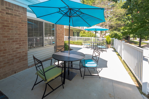 A cozy outdoor seating area featuring colorful umbrellas and a dining table, perfect for enjoying sunny days.