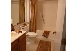 A well-organized bathroom with a bathtub, toilet, sink, and mirror.