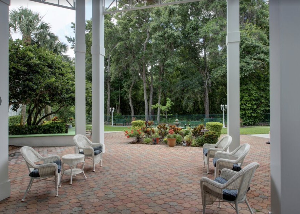 A serene patio with outdoor seating overlooking a lush garden.