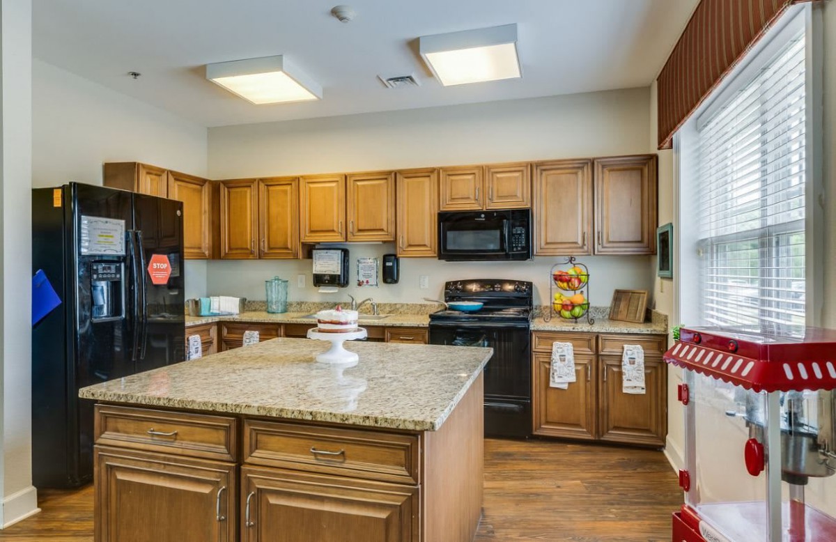 A modern kitchen interior with wooden cabinets and a central island.
