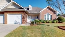 A charming suburban house with a well-manicured lawn and driveway.