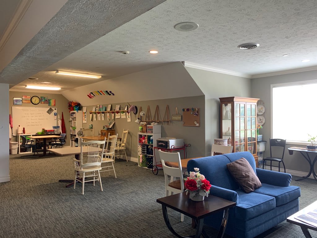 Cozy living room with a sofa, chairs, and table, adorned with decorations.