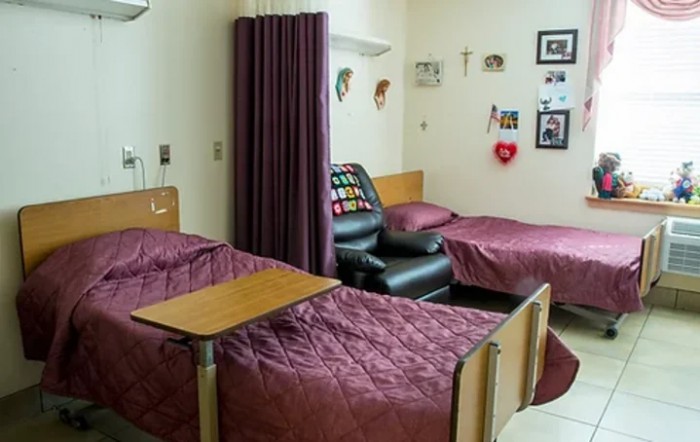 A shared hospital room with two beds and a curtain divider.