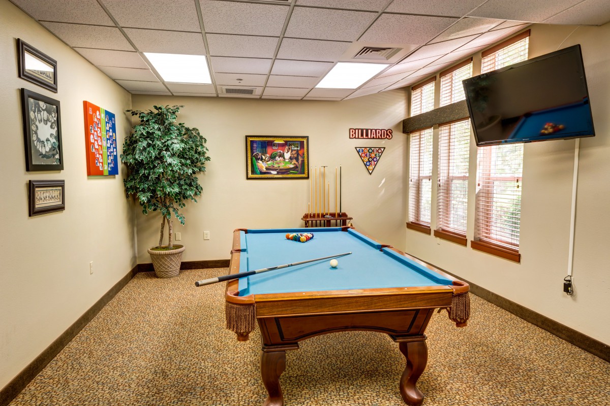 A cozy game room with a billiard table and stylish decor, perfect for relaxation and entertainment.