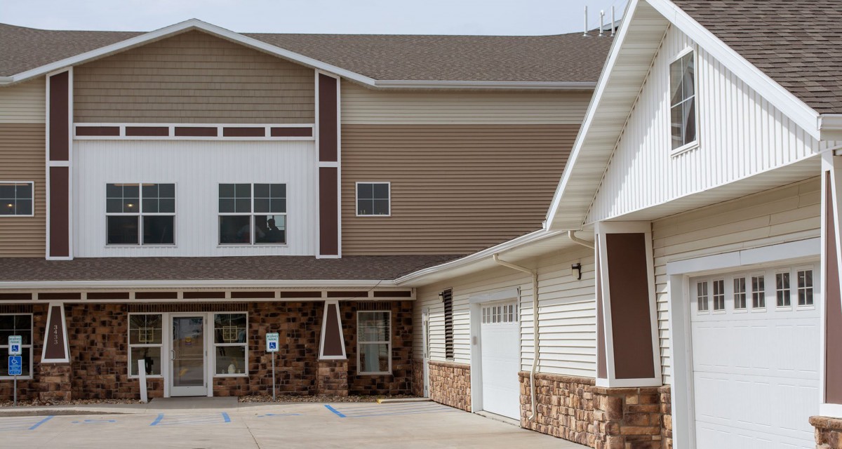 A modern residential building with a mix of stone and siding exterior.