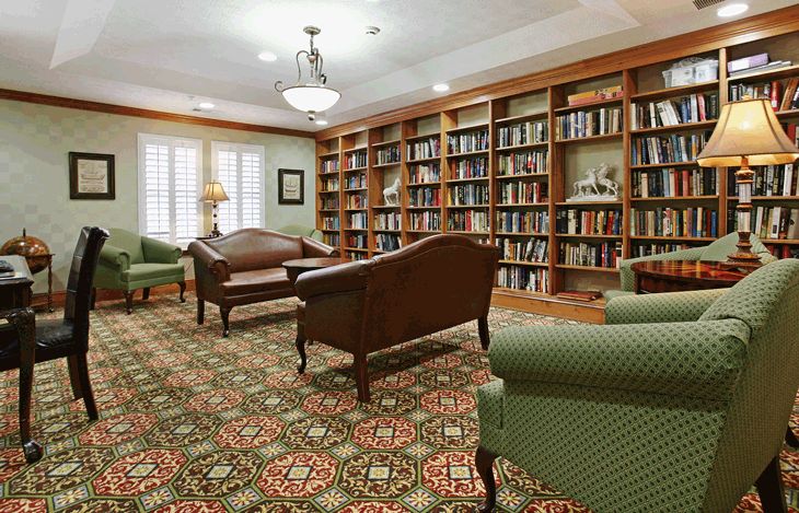 A comfortable library with ample seating and bookshelves lining the walls.