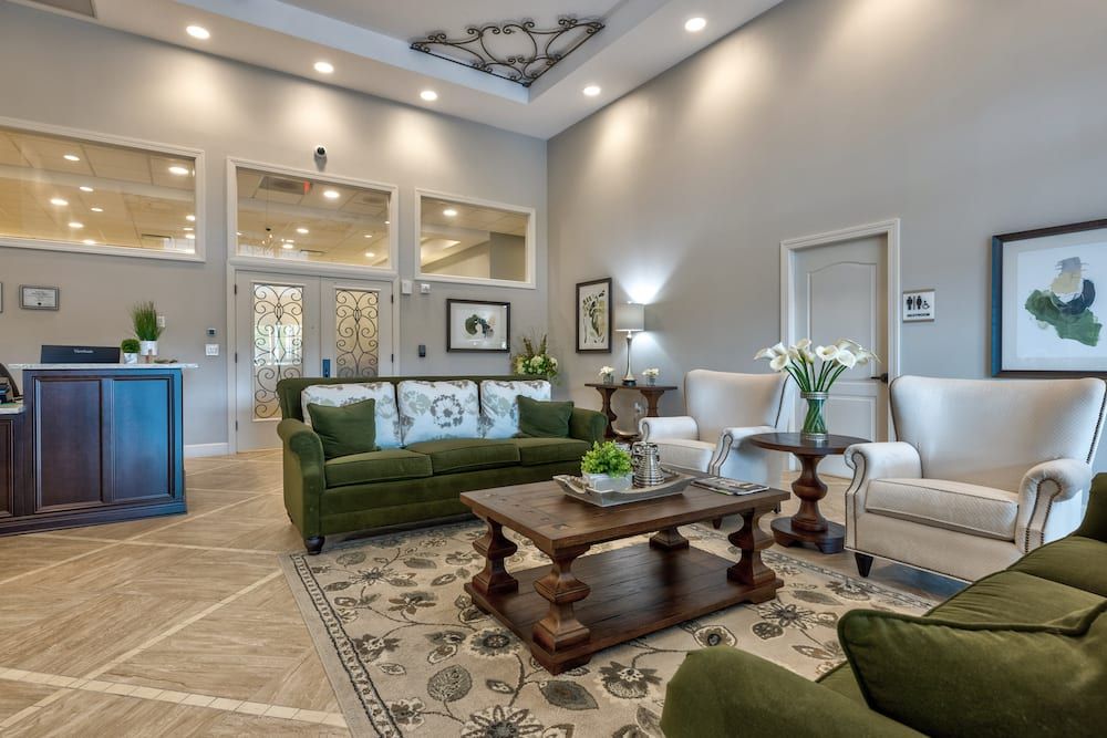 A modern living room with green sofas, a wooden coffee table, and elegant decor.