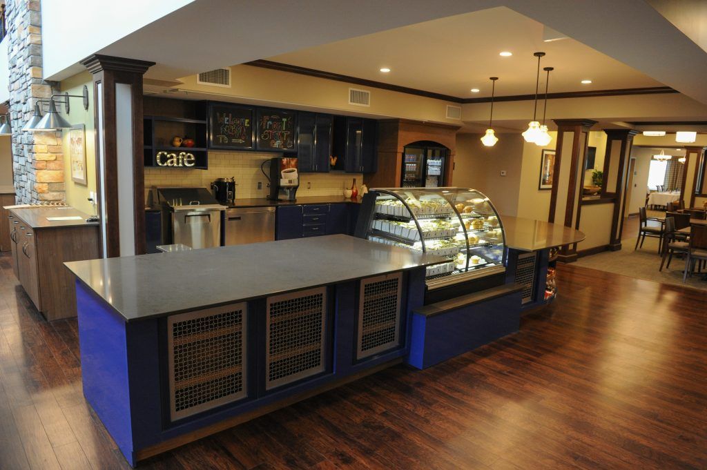 A cozy cafe interior featuring a counter with display cases and warm lighting.