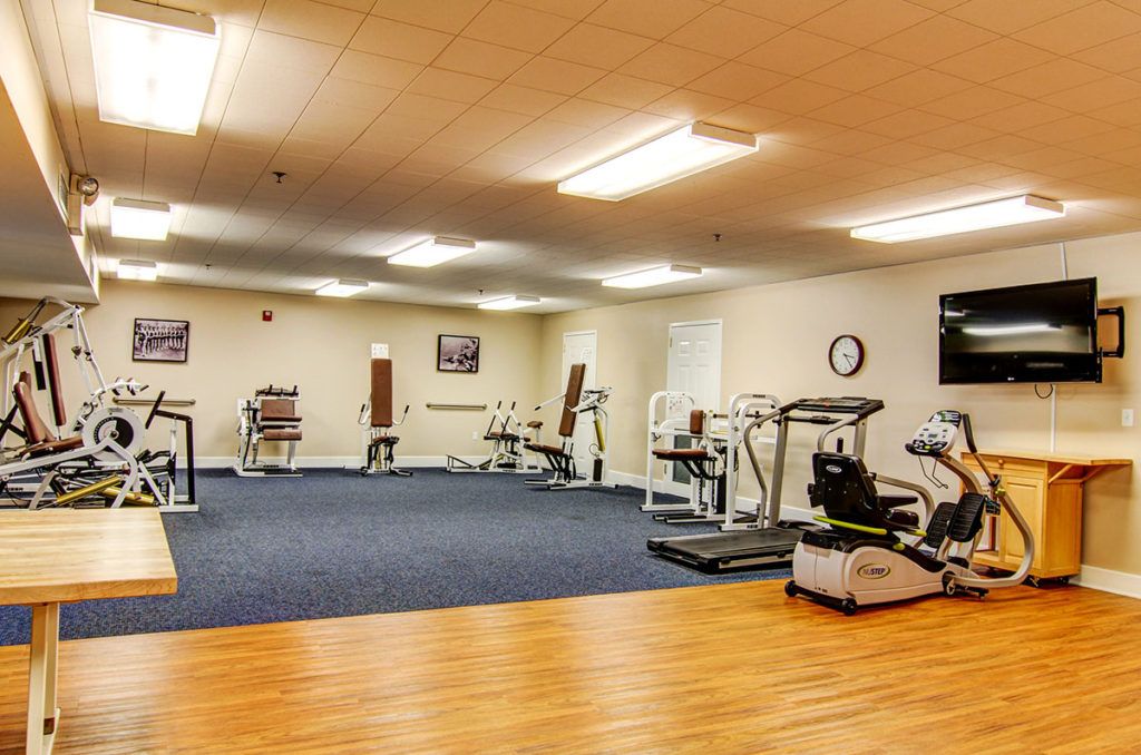 A spacious gym with a variety of exercise equipment, including treadmills and weight machines.