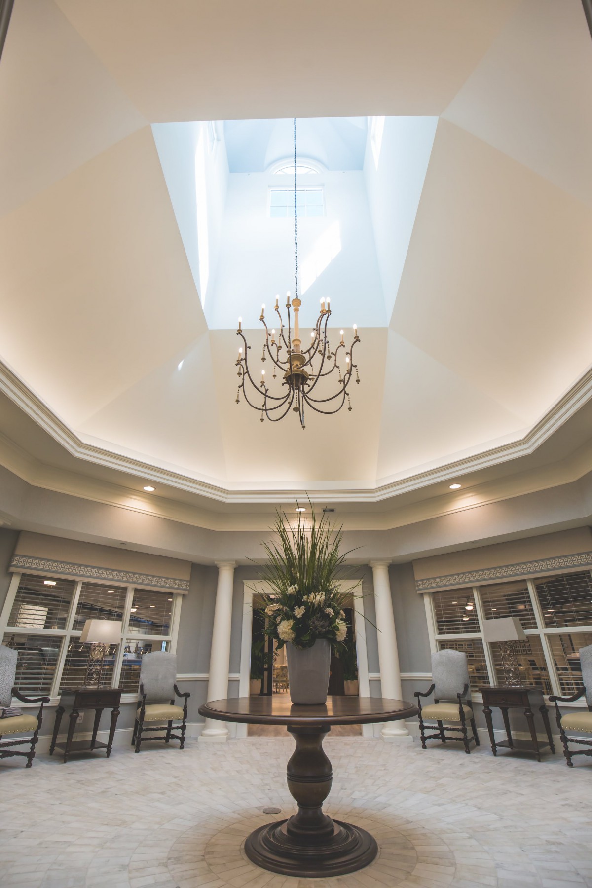 Luxurious dining area with a central skylight and elegant chandelier.