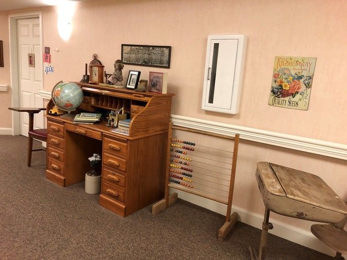 A vintage-themed room with an old wooden desk, globe, and typewriter.