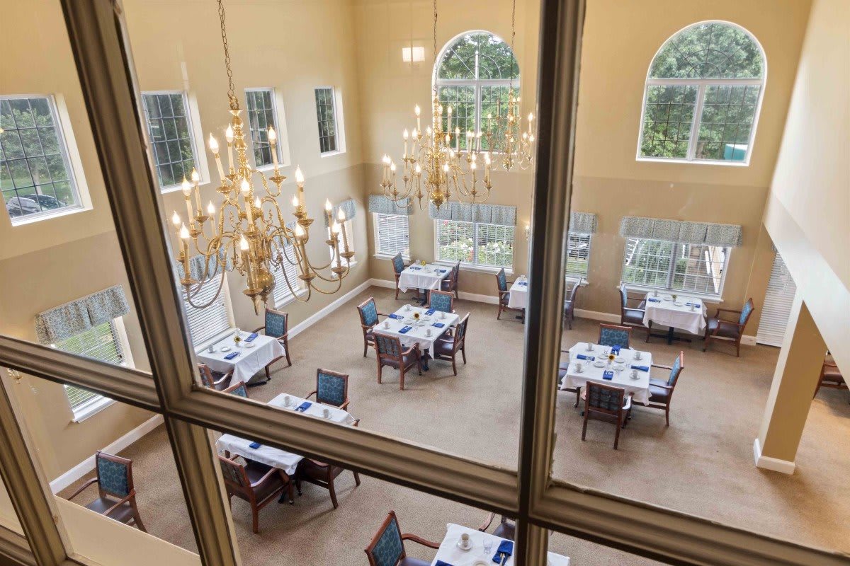 A view of an elegant dining room with chandeliers and tables set for guests.