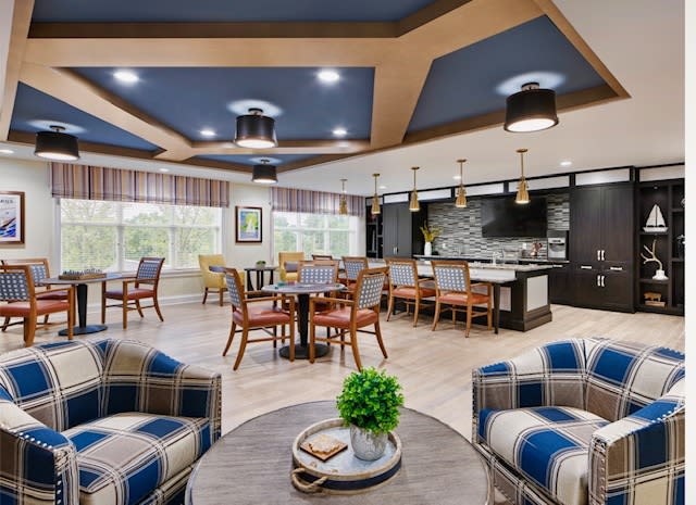 A modern and cozy lounge area featuring comfortable seating, a stylish kitchen, and elegant lighting.