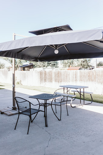 A peaceful outdoor seating area with a large umbrella providing shade.