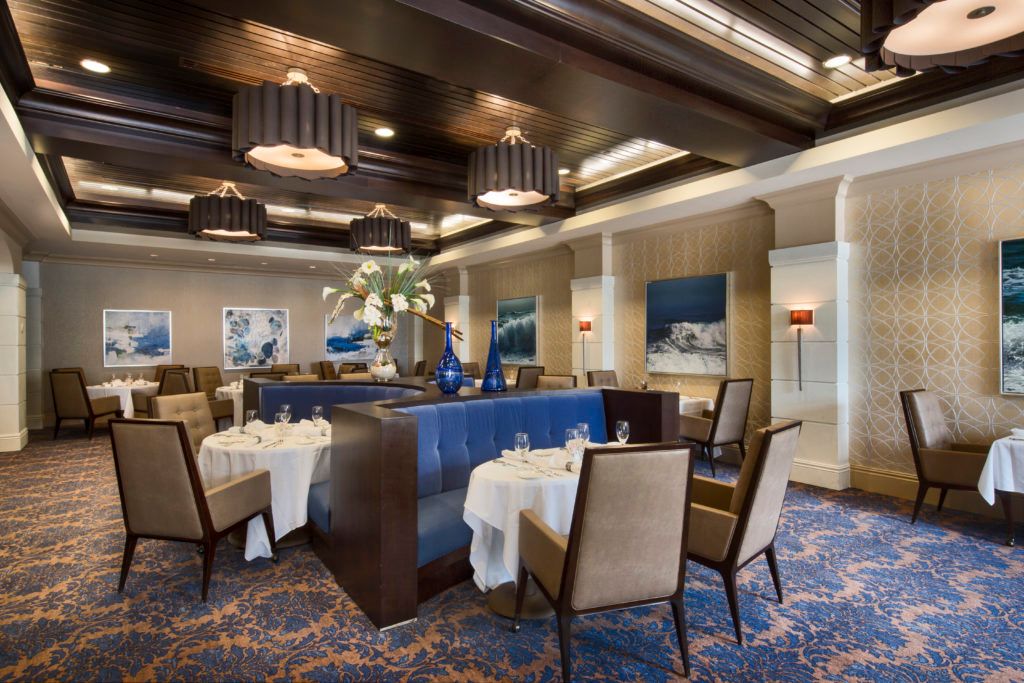 An elegant restaurant interior with neatly arranged tables and sophisticated lighting.