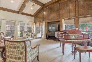 A spacious living room featuring a grand piano and elegant wood paneling.