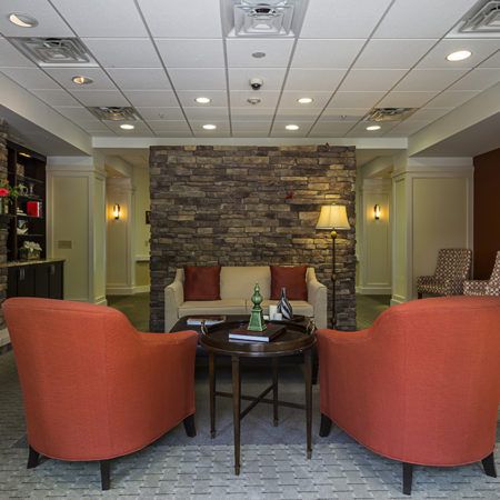 A cozy lobby seating area with comfortable chairs and a stone accent wall.