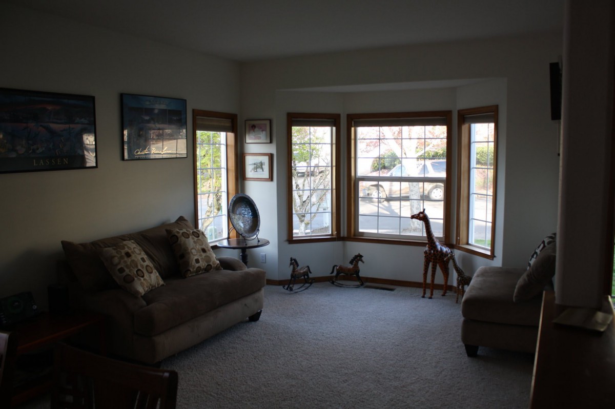 A cozy living room with sofas, large windows, and decorative elements including a giraffe sculpture.