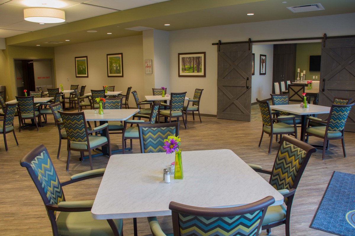 A cozy dining area featuring neatly arranged tables and chairs with modern decor.