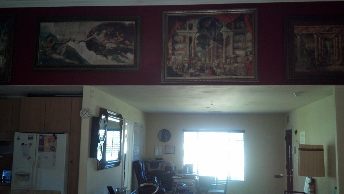 A cozy living room with decorative paintings and a window allowing natural light to fill the space.