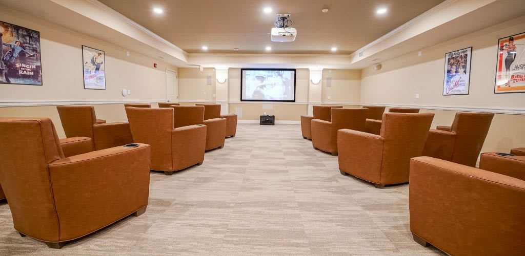 A cozy home theater room with comfortable seating and a large screen.