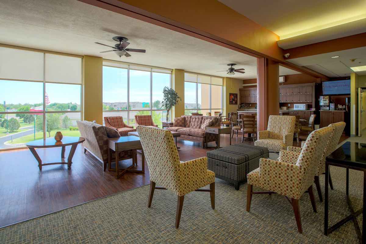 A spacious living room with multiple seating areas, large windows, and ample natural light.