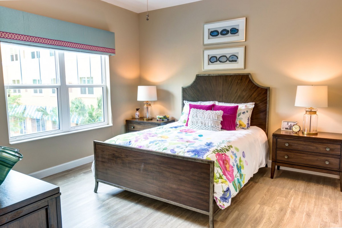 A cozy and colorful bedroom with a wooden bed, vibrant bedding, and elegant decor.