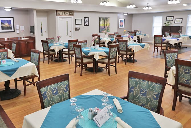 A neatly arranged dining area with tables and chairs, set up for service.