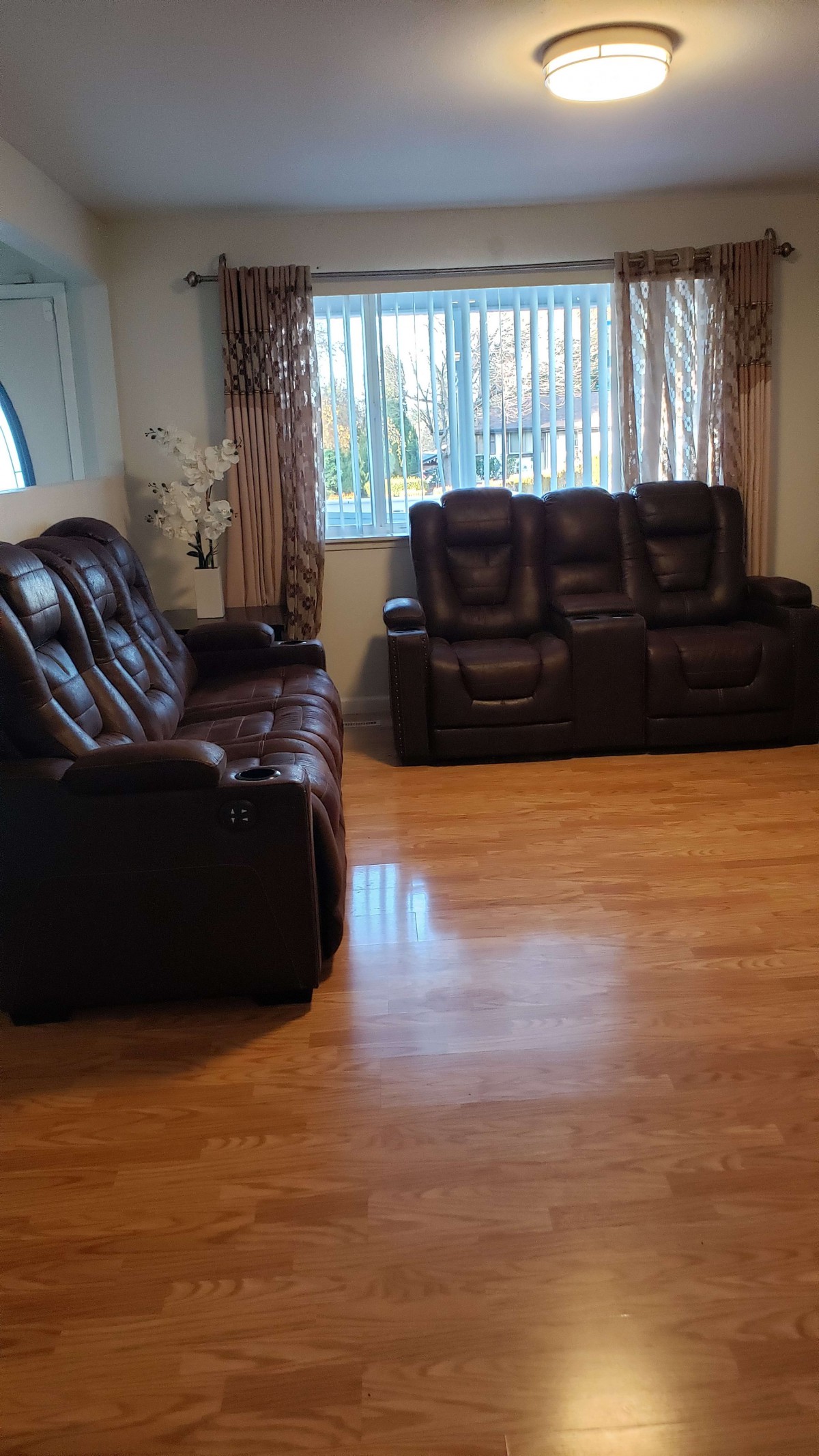 A living room with leather sofas and a hardwood floor.