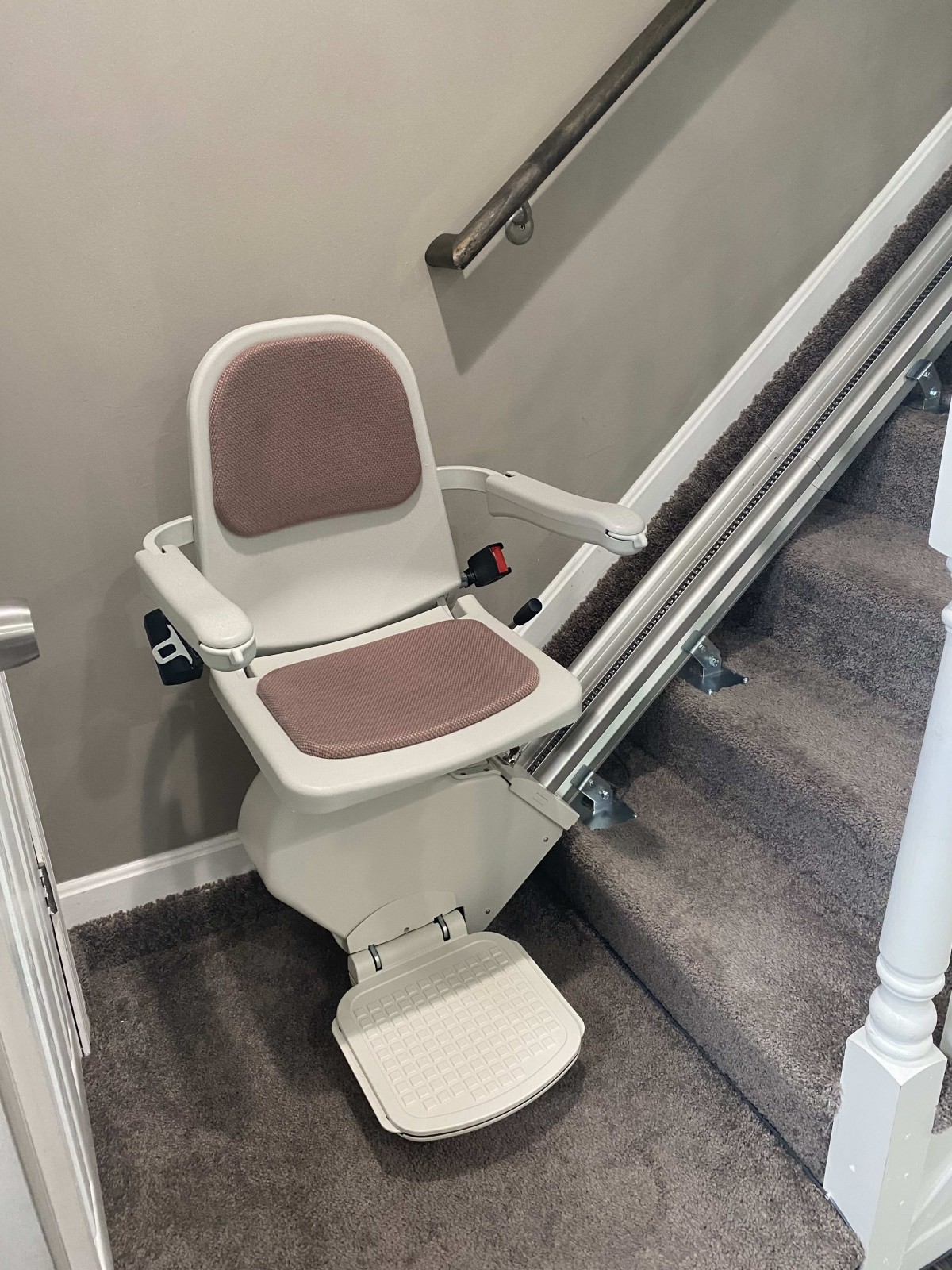 A stairlift installed on a staircase, providing accessibility assistance.