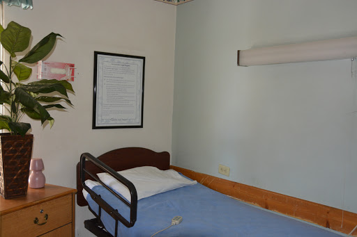 A view of a hospital room featuring a single bed and minimalist decor.
