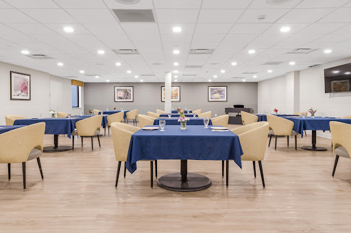 An organized dining area with blue tablecloths and modern furniture, ready for guests.