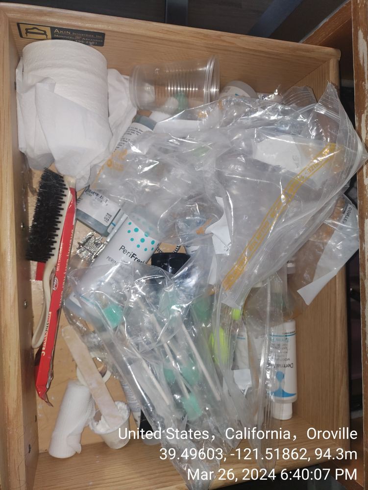 A drawer filled with various travel-size toiletries and personal care items.