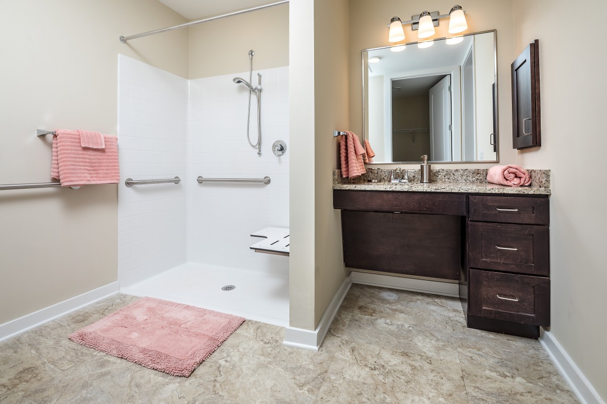 A modern bathroom featuring a walk-in shower and a vanity with a large mirror.