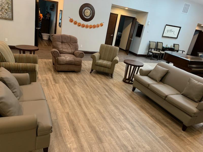 A comfortable waiting room with various seating options and tables, featuring neutral decor.