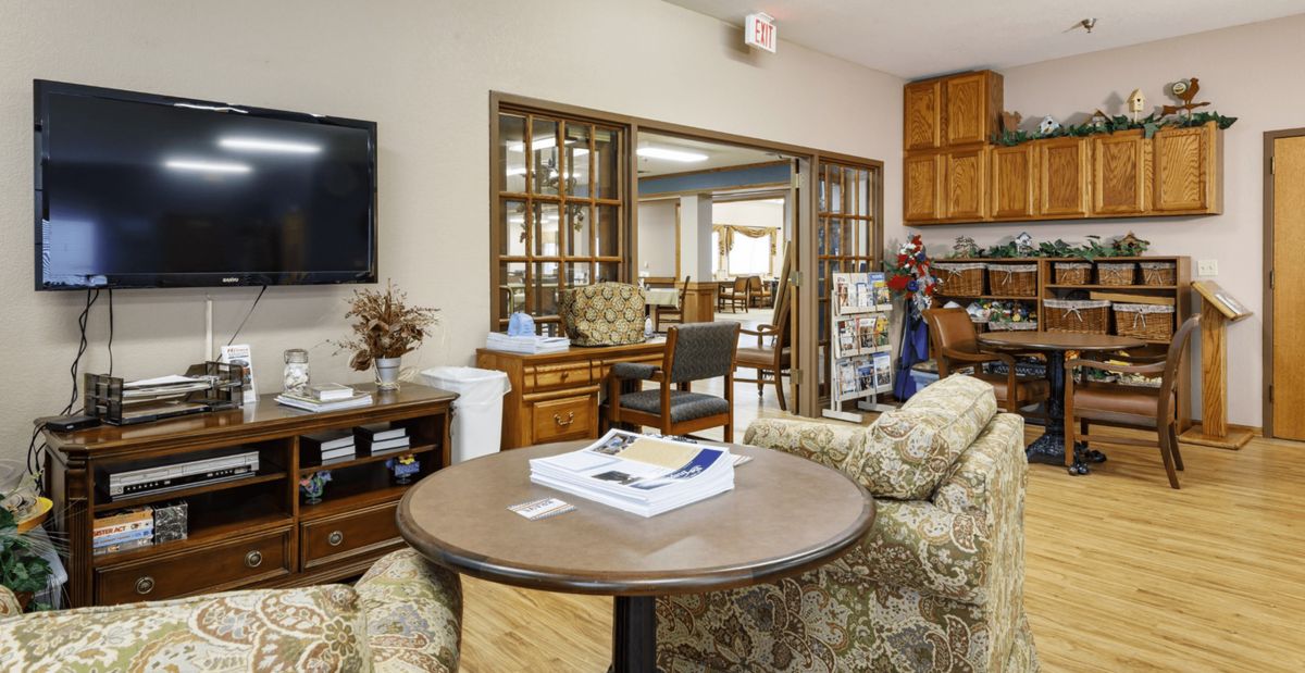 A cozy living room with a round table, sofa, television, and bookshelf.