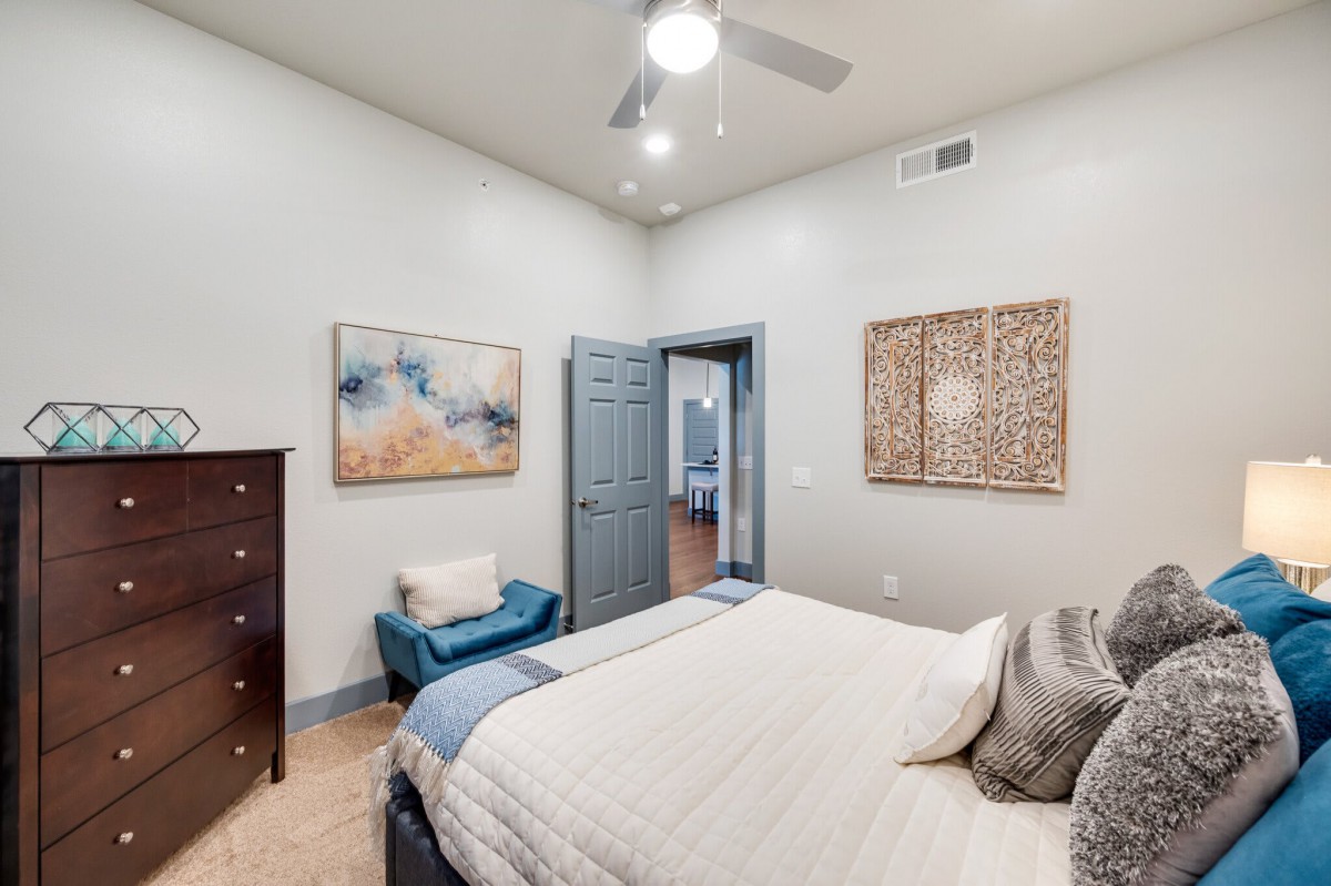 A modern bedroom interior with stylish decor and artwork on the walls.