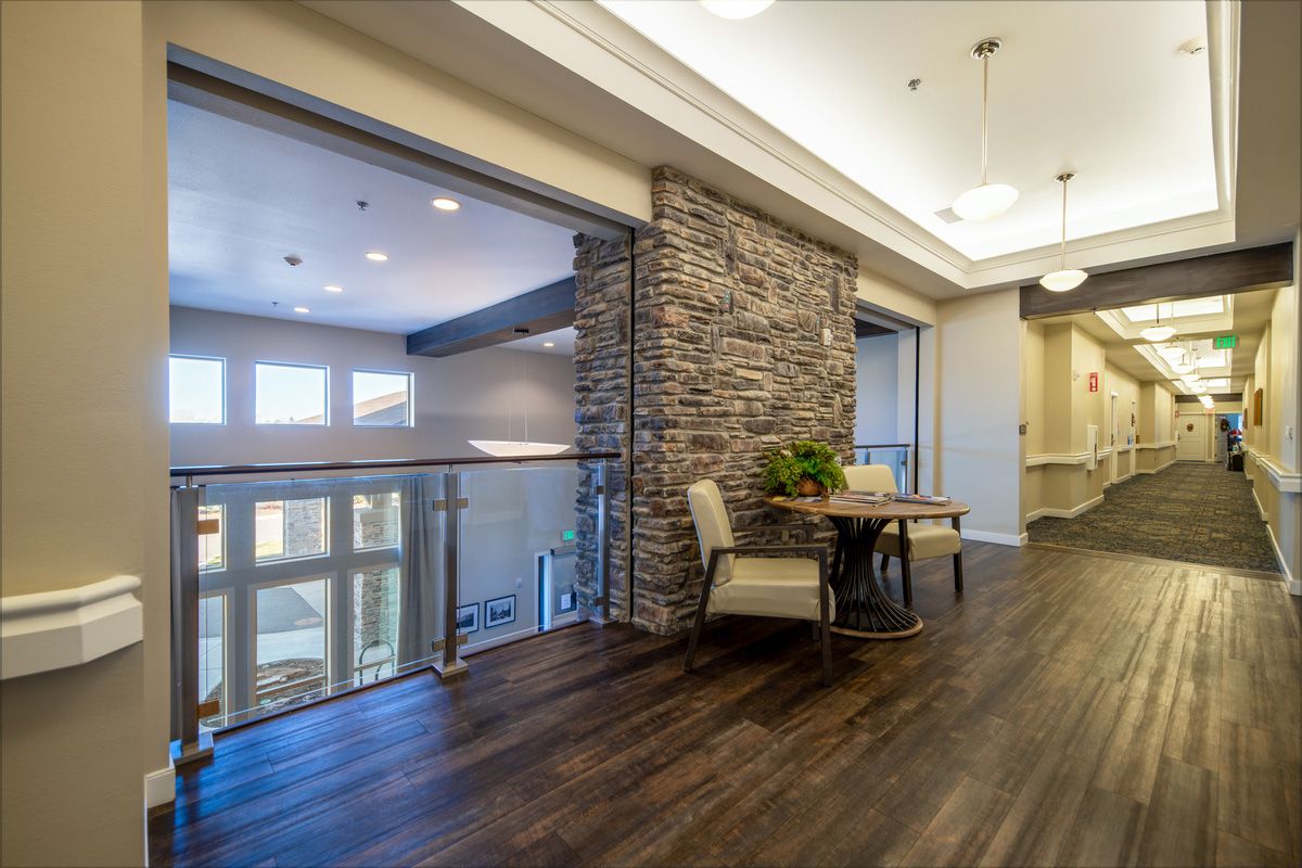 A modern home interior featuring a stone accent wall and hardwood flooring, with an open view of the living area.