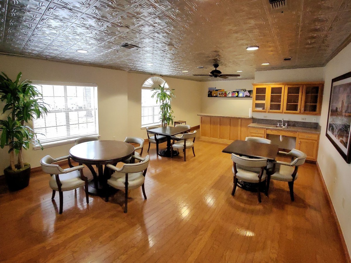 Spacious dining area with wooden floors and multiple tables.