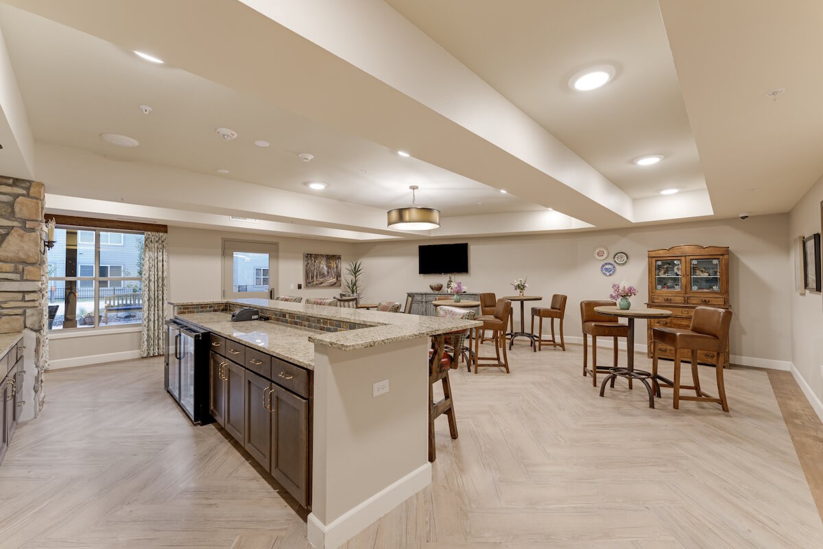 A spacious, modern basement bar area with seating and a television.