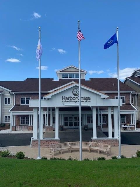 A nursing home building with three flags displayed out front.