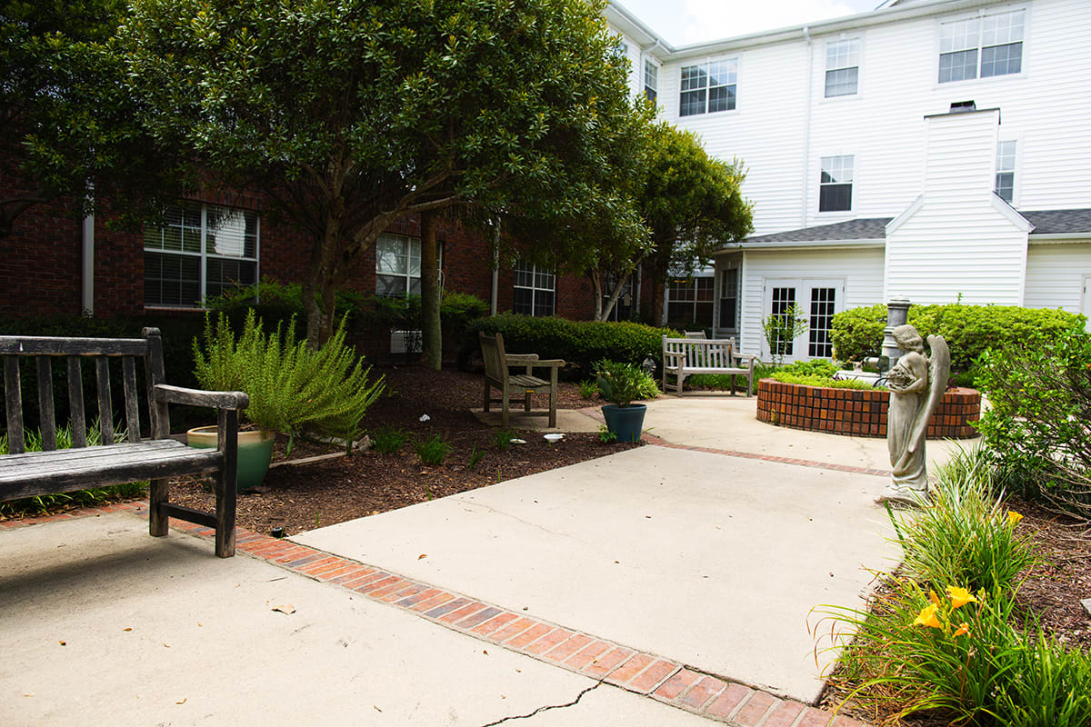 A serene outdoor area with benches and greenery in front of a building.