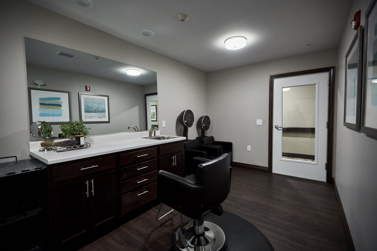 Modern hair salon interior with a barber chair and vanity.