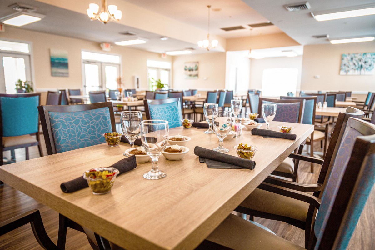 A well-set dining area in a restaurant with neatly arranged tables and chairs.
