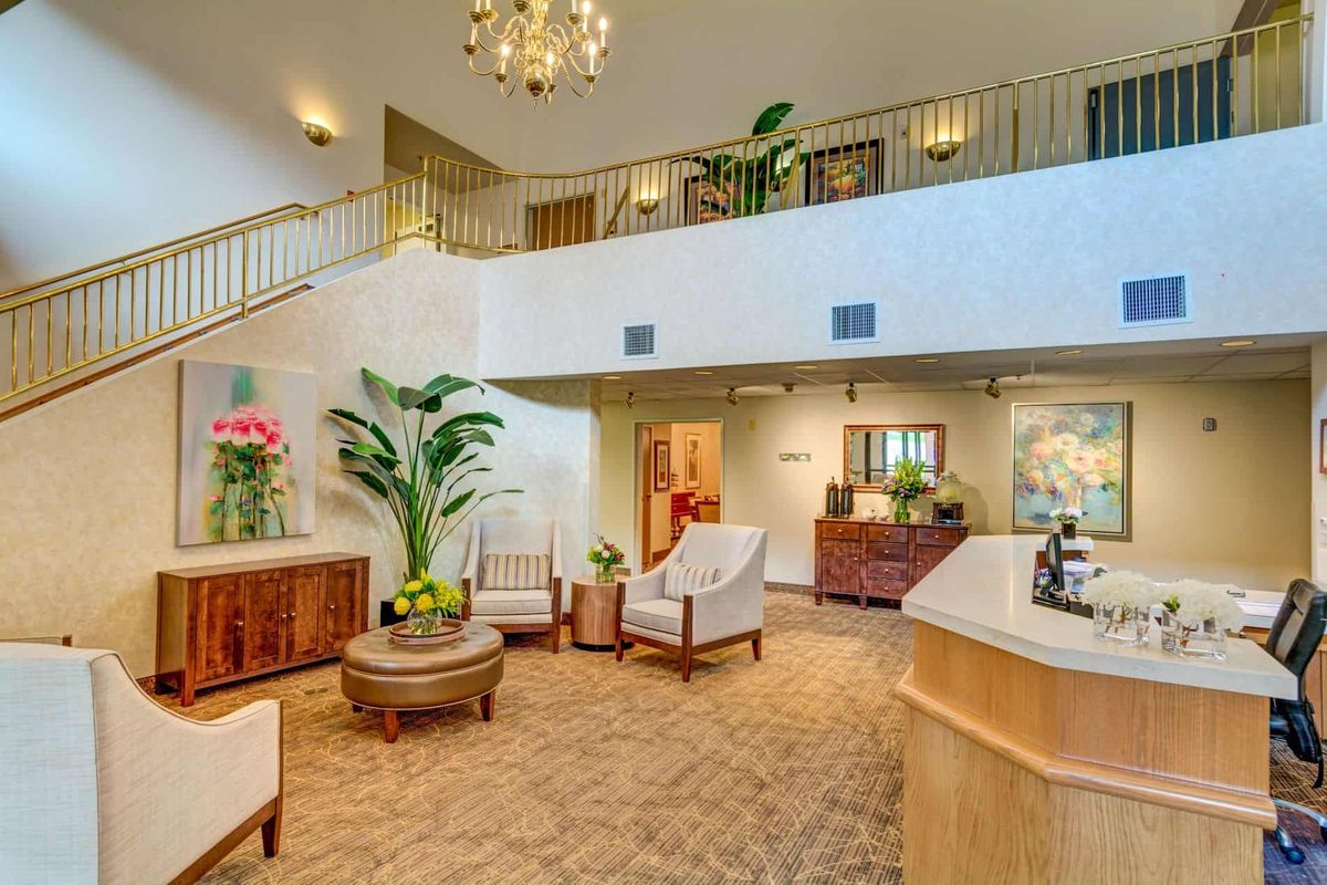 A spacious and elegantly designed lobby with comfortable seating, a chandelier, and decorative plants.