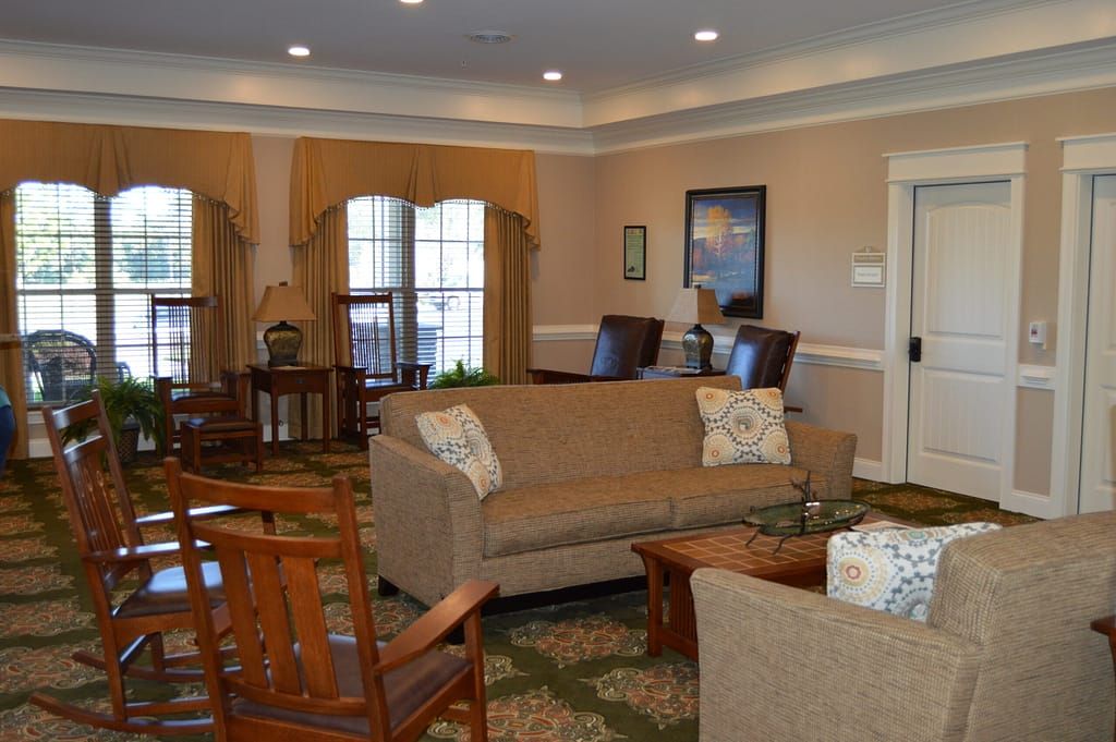 A cozy and well-furnished living room with sofas, chairs, and a large window.